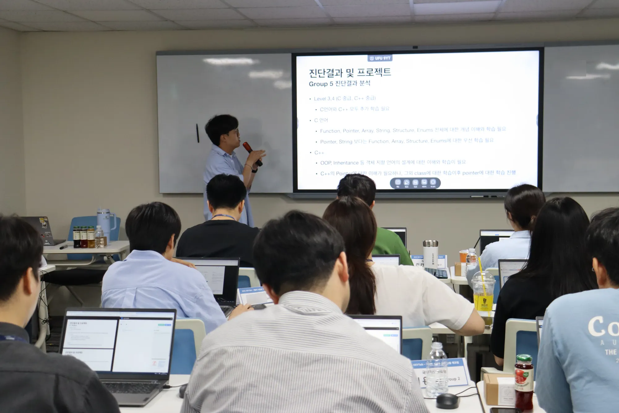 현대오토에버 Devtalk C/C++ 트랙 디브리핑 현장에서 진단 결과를 설명하는 연사님의 모습과 설명을 듣는 참여자들의 뒷모습